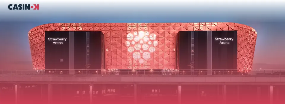 Strawberry Arena upplyst i rött med logotyp, en central plats för livebetting och sport.